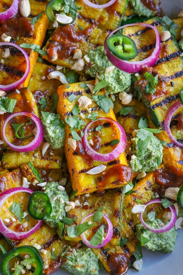 Curry-spiced grilled zucchini topped with herbs and red onion
