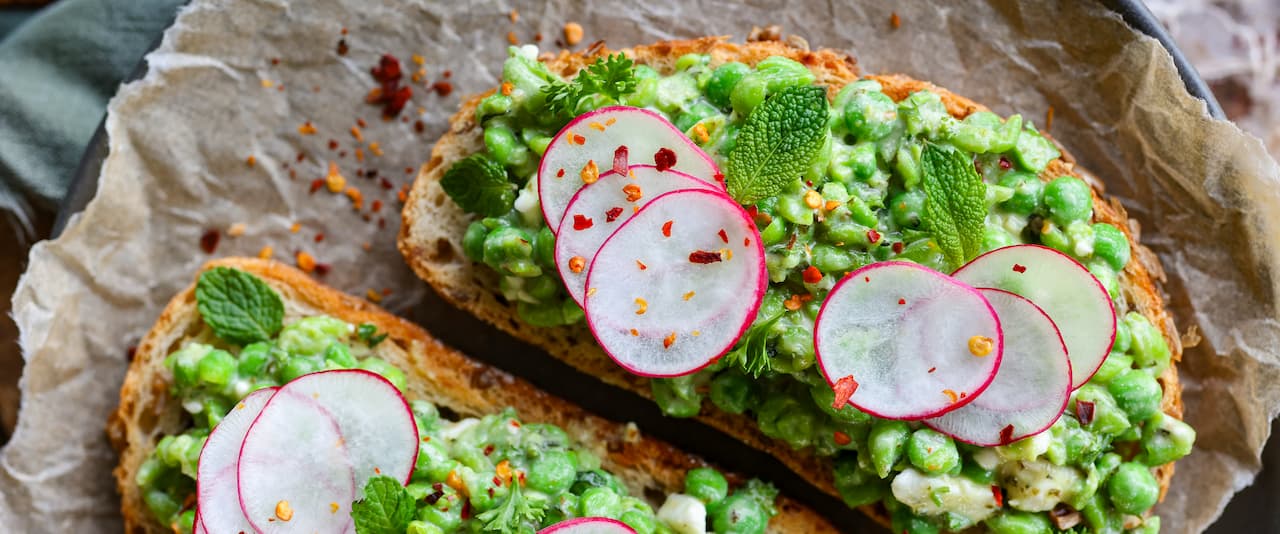 Smashed green peas toast topped with radish slices